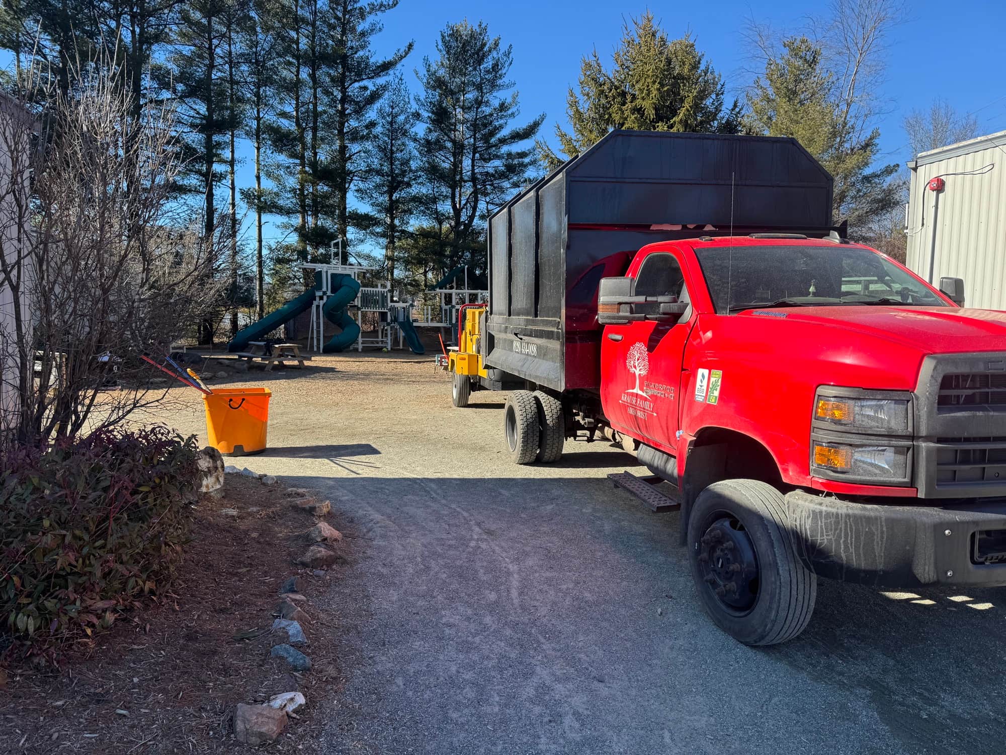 Krause Arborist red chip truck at commercial tree care job site