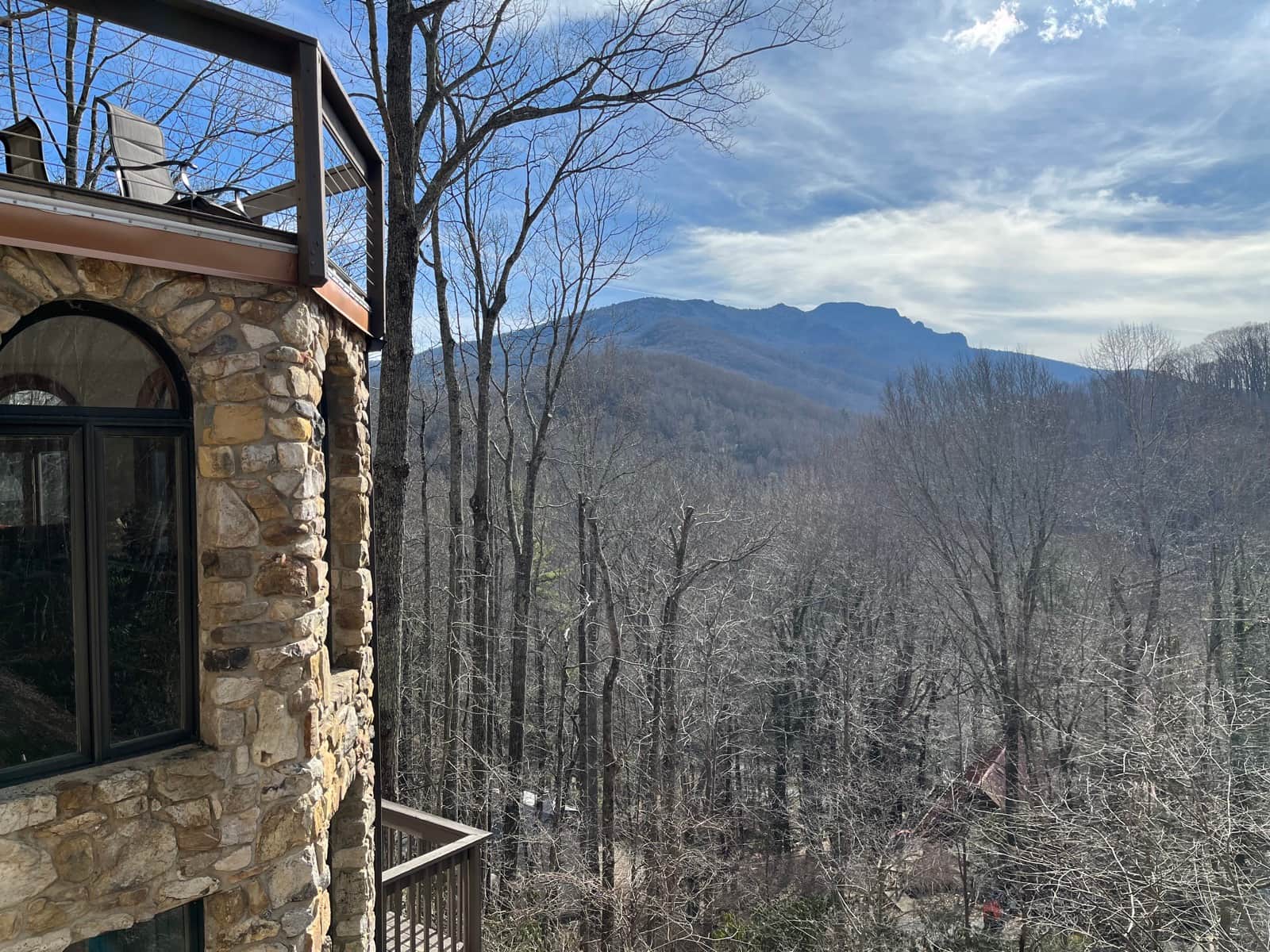 View of Grandfather Mountain through cleared trees from a stone house after view enhancement work